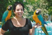Carmen posing with a pair of toucans.